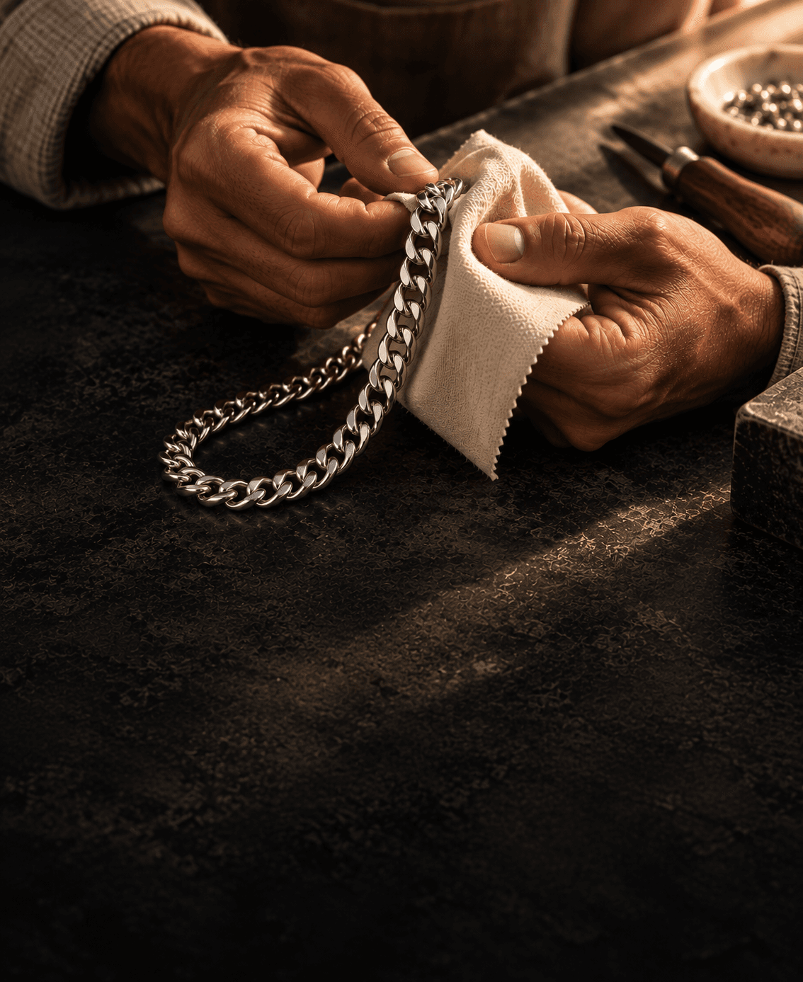 An artisan hand-polishing a sterling silver curb chain