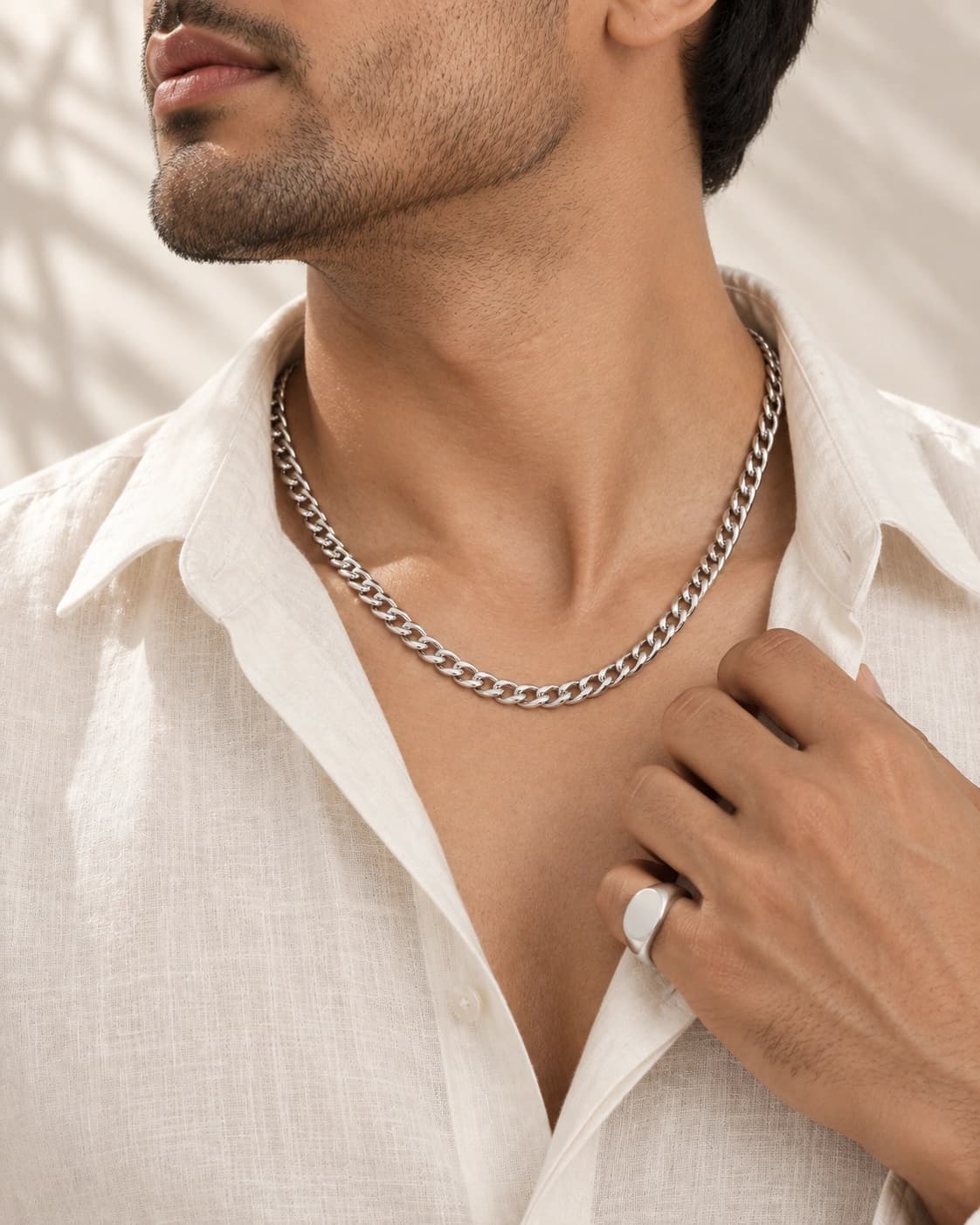 Man wearing a sterling silver curb chain and signet ring